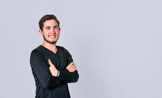 Happy handsome man with crossed arms, portrait of an attractive guy with crossed arms on isolated background, smiling person with crossed hands