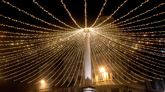 Large canopy made of light dots around column in town square in Lugo city, Galicia, Spain. Christmas decorations.