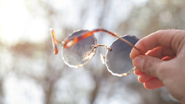 istock Human hand holding sunglasses in outdoors. 1390422263