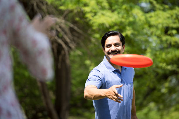 istock Happy man throwing frisbee disc at park 1390426243