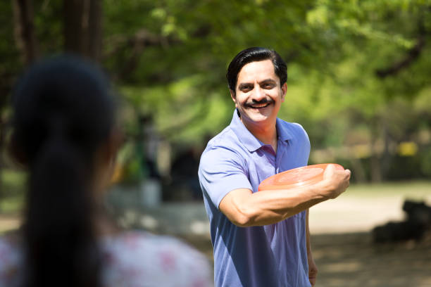 istock Happy man throwing frisbee disc at park 1390426348