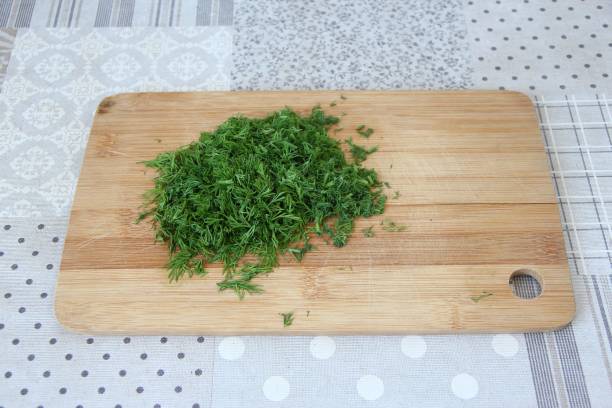 Chopped dill on the wooden cutting board Chopped dill on a wooden cutting board chopped dill stock pictures, royalty-free photos & images