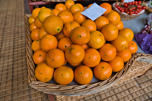 A lot of Orange fruits in big basket on traditional fruits market