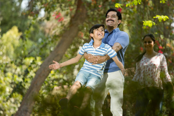 istock Happy family having fun at park 1390429418