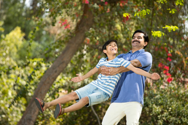 istock Carefree father spending leisure time with son at park 1390429435
