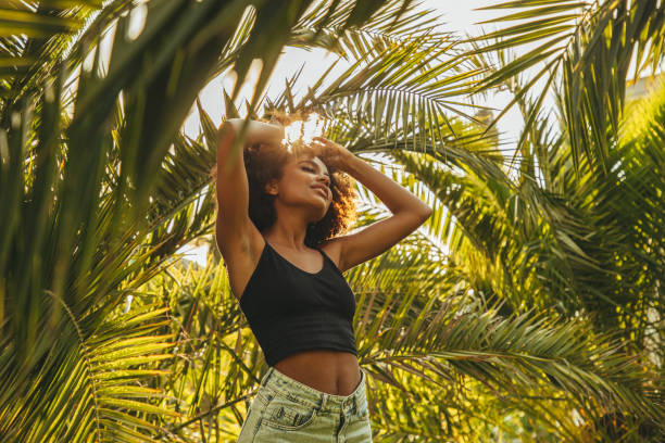 istock Pretty young afro woman among palm trees 1390429715