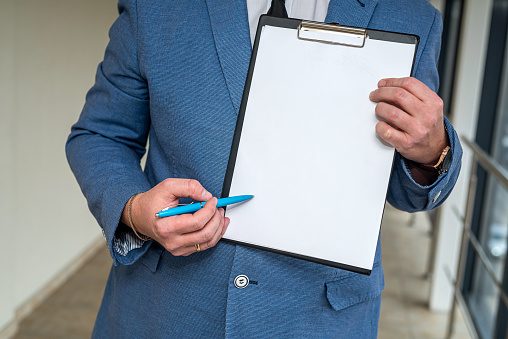 stylish young businessman in a classic suit and white shirt holding a tablet and pen. Businessman concept