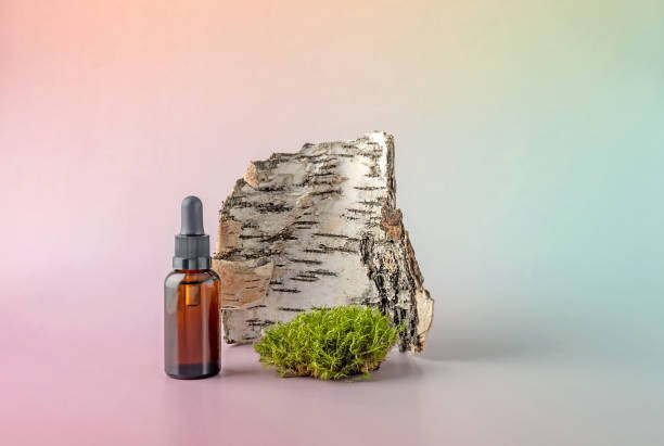 istock bottle with a pipette, birch bark and moss on a gradient background 1390435243