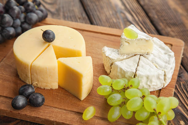 istock Assorted cheeses,Camembert and gouda cheese on a wooden cutting board with different types of grapes,copy space. 1390437622