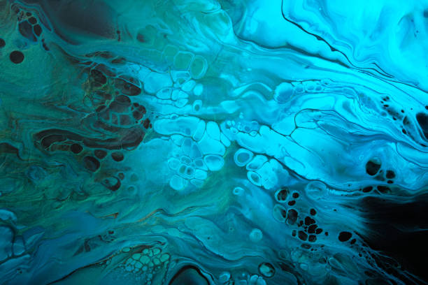 istock Fluid Art. Green and fluorescent blue abstract wave swirls on black background. Marble effect background or texture 1390439432