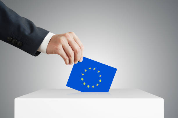 istock Man putting a ballot into a voting box. 1390441807