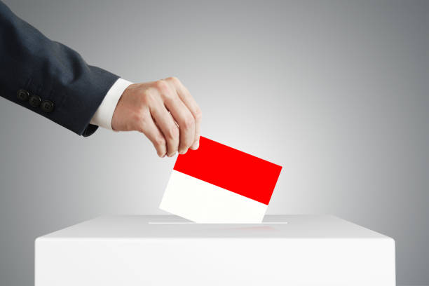 istock Man putting a ballot into a voting box. 1390442492