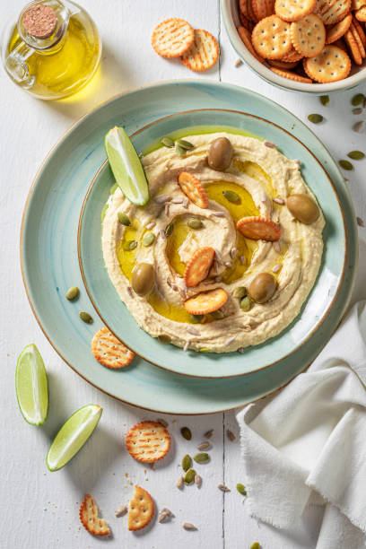 istock Yummy and fresh hummus with round crackers and olives. 1390443933