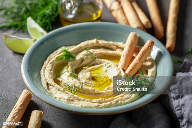 Tasty And Homemade Hummus With Breadsticks Olive Oil And Dill Stock Photo - Download Image Now