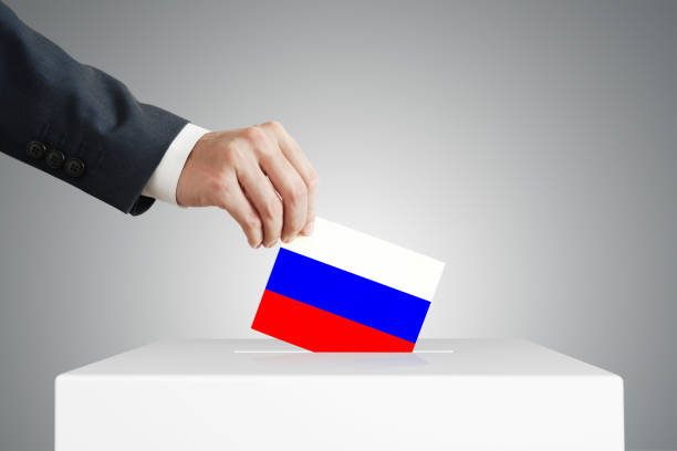 istock Man putting a ballot into a voting box. 1390444740