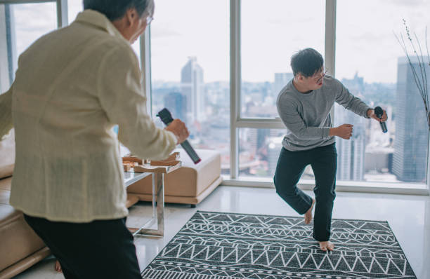 istock multi generation Asian Chinese down syndrome young man singing dancing with grandmother having fun in living room during weekend 1390444943