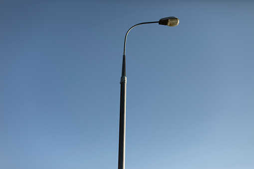 Pillar against sky. Lighting fixture in city. Pole with lamp. City facility.