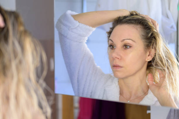istock Woman with open hair looking at mirror 1390448651