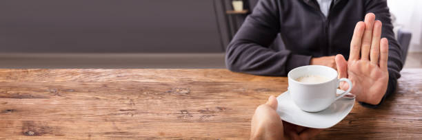 istock Man Refusing Cup Of Coffee Offered By Person 1390450568