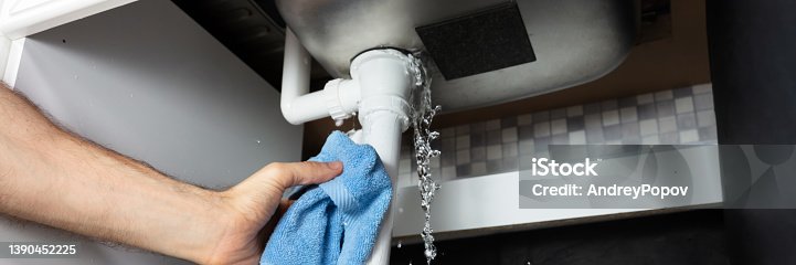 istock Male Hand's Holding Blue Napkin Under Leakage Pipe 1390452225
