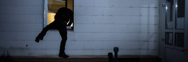 istock Burglar Entering In A House Through A Window 1390452399