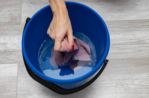istock hands squeeze a rag from water in a bucket 1390452525