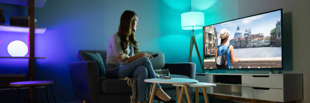 istock Woman Watching TV While Relaxing On Sofa 1390452542