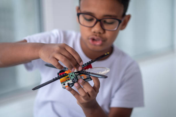 istock A boy in eyeglasses playing with a toy helicopter 1390452804