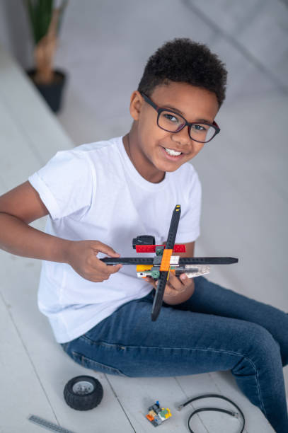 istock A boy in eyeglasses playing with a toy helicopter 1390452821