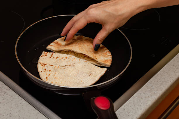 istock a woman's hand flips a frying cake in a frying pan 1390453522