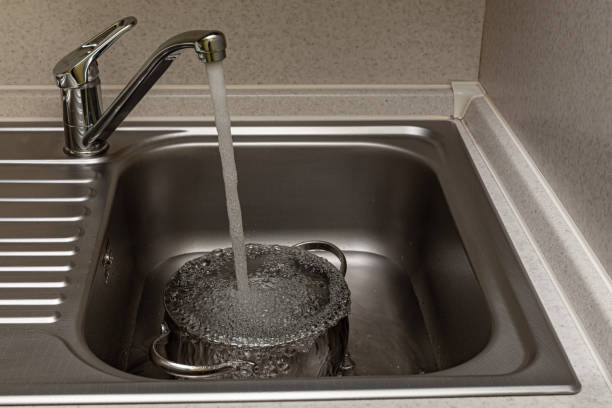 istock tap water is poured into the pan in the sink 1390453536