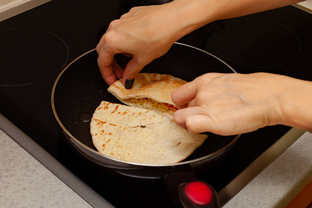 istock a woman's hand flips a frying cake in a frying pan 1390453587