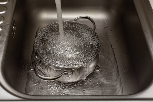 istock tap water is poured into the pan in the sink 1390453602