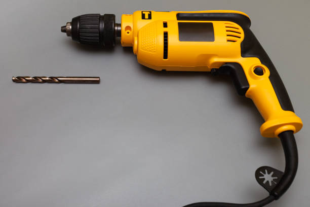 istock yellow household drill next to which lies a drill 1390454080