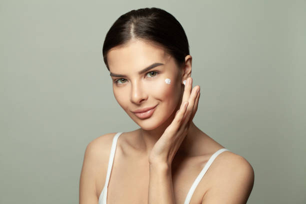 istock Young woman with creame on her face on white background 1390454752