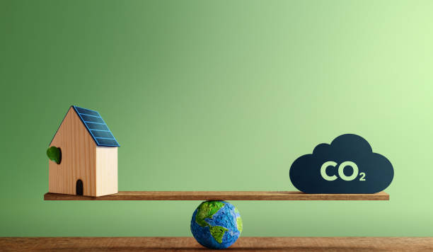 istock Carbon Neutral Concepts. Clean Energy. Green Power. Globe Balancing between a Solar Rooftop House and CO2 icon. Sustainable Resources, Environmental Care 1390456656