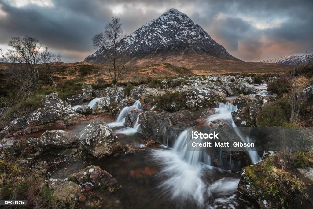 Epic majestic Winter sunset landscape of Stob Dearg Buachaille Etive Mor iconic peak in Scottish Highlands with famous River Etive waterfalls in foreground Stunning majestic Winter sunset landscape of Stob Dearg Buachaille Etive Mor iconic peak in Scottish Highlands with famous River Etive waterfalls in foreground Nature Stock Photo