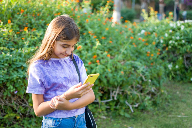 istock Beautiful girl using mobile phone to parkland 1390457380