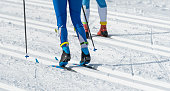 Close up of skis, shoes and legs of  cross country skiers in action. Shallow depth of field.