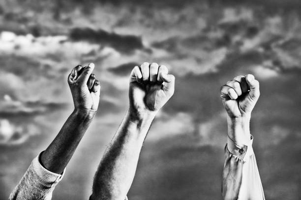 istock Three diverse hands giving clenched fist salute against the sky 1390458749