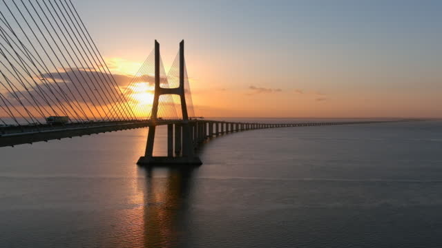 Aerial view of the Vasco da Gama bridge in Lisbon at dawn and trafic all around that passes by