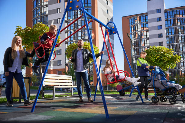 istock Large family with four kids by swing set. 1390468161