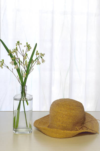 istock White Flowers & Straw Hat on the Table 1390468322