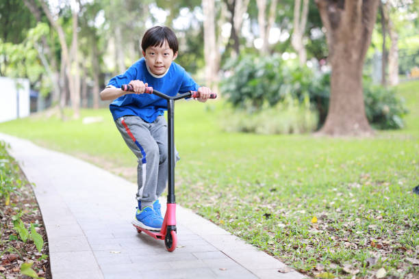 istock Asian boy riding scooter 1390471300