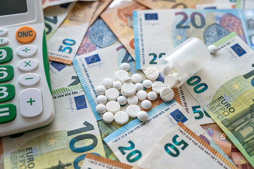 pharmacy high cost concept - pills money and calculator. finance