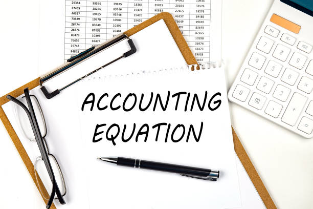 Text ACCOUNTING EQUATION on the white paper on clipboard with chart and calculator stock photo