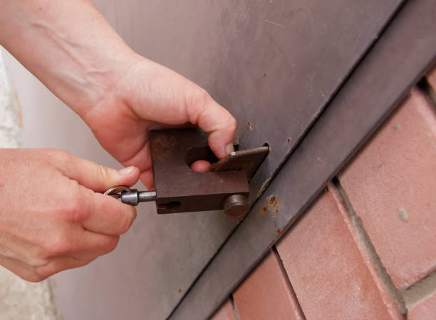 istock Women's hands open a rusty lock with keys. Lock on a metal door. Security. 1390476533
