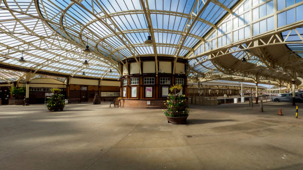 Wemyss Bay, Scotland, UK - April 07, 2022: View of the train station and ticket office at Wemyss Bay in Inverclyde, Scotland, \nThe station, noted for its architectural qualities and one of Scotland's finest railway buildings, was designed by James Miller in 1903 for the Caledonian Railway and is remarkable in its use of glass and steel curves.\nPicture is a panorama formed from 4 images stitched together.