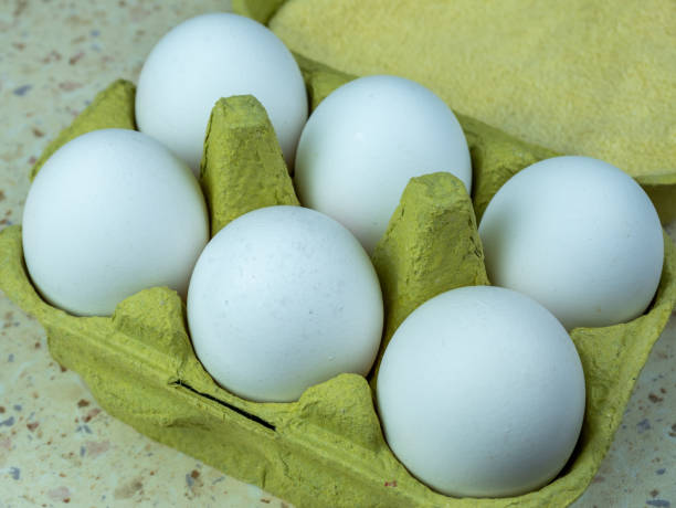 istock Six white eggs in a green egg box, close-up. Selective focus. 1390480581