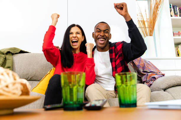 istock Friends enjoy watching TV, cheering. 1390480622